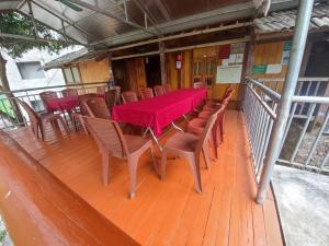 una mesa roja y sillas en una terraza de madera en Anh dược homestay en Bak Kan