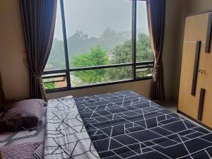- une chambre avec un lit et une grande fenêtre dans l'établissement Bobo Queen House 5 villa baba ( mountain view), à Puncak