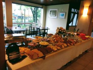 una mesa de buffet con mucha comida. en Brisamar Suite Hotel en Florianópolis