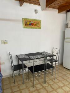 a table and chairs in a kitchen with a refrigerator at Refugio El Jazmín in Posadas