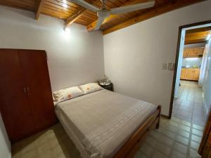 a bedroom with a bed and a wooden ceiling at Refugio El Jazmín in Posadas