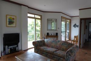 a living room with a couch and a television at Sea Banksia in Denmark