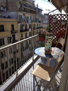 塞薩羅尼基的住宿－Nasos Cozy Place，阳台配有桌椅,享有建筑景致