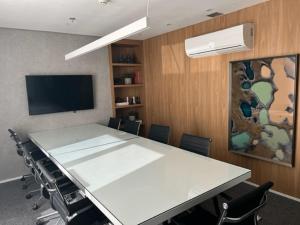 een vergaderzaal met een grote witte tafel en stoelen bij Blend Marista - apt 1 Qt in Goiânia