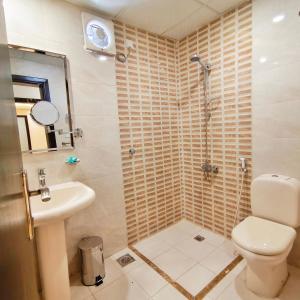 a bathroom with a shower and a toilet and a sink at فندق الساعي Alsai Hotel in Al ‘Utaybīyah