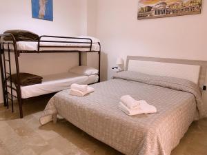 a bedroom with two bunk beds with towels on them at L'Anfiteatro di Pompei B&B in Pompei