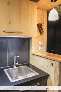 a kitchen with a stainless steel sink and wooden cabinets at Les Balcons Montagnards in Ax-les-Thermes