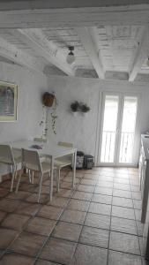 une salle à manger avec une table et des chaises blanches dans l'établissement EL BOTIJO Las puertitas rojas, à Ubrique