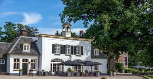 a white house with a tower on top of it at Hotel Kasteel Hoekelum in Bennekom