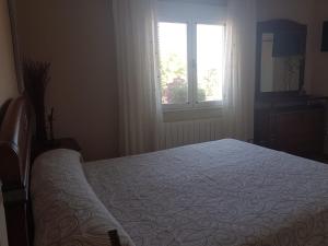 Un dormitorio con una cama grande y una ventana en CASA RURAL EL SAUCE. A 2,5 KM DE CUENCA CAPITAL en Nohales