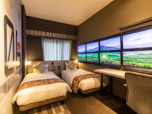 two beds in a room with a large window at HALE Kyoto Tambaguchi ハレ京都丹波口 in Kyoto
