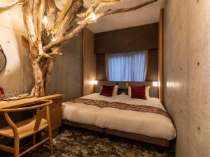 - une chambre avec une branche d'arbre au-dessus du lit dans l'établissement Hale Kyoto Tambaguchi#Tabist, à Kyoto
