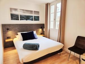 - une chambre avec un lit et un oreiller dans l'établissement Hôtel du Port, à Saint-Martin-de-Ré