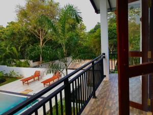 a balcony with two chairs and a pool at Finch Tangalle in Tangalle