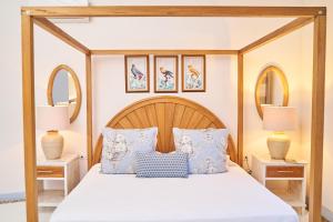sypialnia z łóżkiem z baldachimem i niebieskimi poduszkami w obiekcie El Bosque Hotel Boutique w mieście Doradal