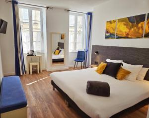 1 dormitorio con 1 cama grande y escritorio en Hôtel du Port en Saint-Martin-de-Ré