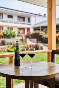 dos copas de vino sentadas en una mesa de madera en Governor's Residence, en Kigali