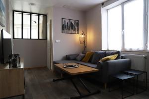 ein Wohnzimmer mit einem Sofa und einem Tisch in der Unterkunft L'appart d'Antoine in Saint-Quentin