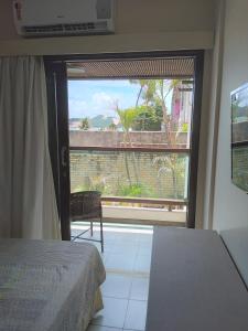 a room with a bed and a large window at Flat a beira mar, vista lateral - Araça 408 in Natal