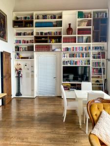 uma sala de estar com uma mesa e uma televisão e livros em VILLA ANCORA Tenuta Lonciano em Gualdo