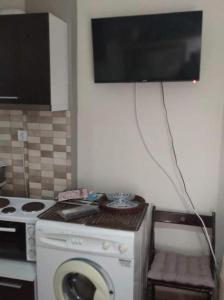 塞薩羅尼基的住宿－Nasos Cozy Place，一间带洗衣机的厨房和一台墙上的电视