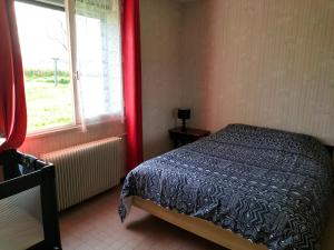 um quarto com uma cama ao lado de uma janela em Gîte le grand bois em Feins-en-Gâtinais