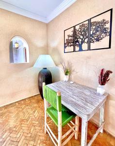 comedor con mesa de madera y silla verde en Villa à Essaouira, en Essaouira