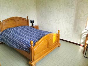 1 dormitorio con cama de madera en una habitación en Gîte le grand bois en Feins-en-Gâtinais