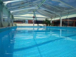 a large swimming pool with blue tiles on top of it at Domki Kamila in Grzybowo