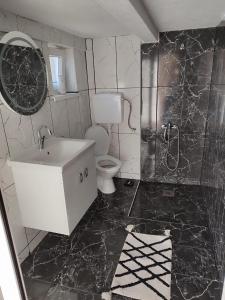 a black and white bathroom with a toilet and a sink at Maksumic Apartman in Mostar