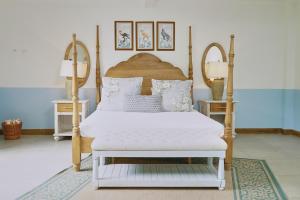 sypialnia z białym łóżkiem z drewnianą ramą w obiekcie El Bosque Hotel Boutique w mieście Doradal