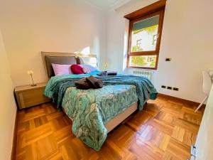 a bedroom with a bed with a green comforter and a window at [Piramide] Luxury Suite Colosseum in Rome