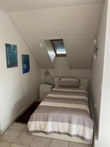 una piccola camera da letto con un letto in mansarda di Das Loft Dachstudio mit Herkulesblick a Lohfelden