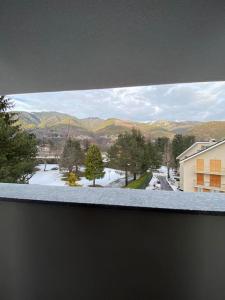una ventana con vistas a una calle cubierta de nieve en Grazioso Bilocale in Val Vigezzo en Craveggia