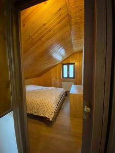 a bedroom with a bed and a wooden ceiling at Grazioso Bilocale in Val Vigezzo in Craveggia