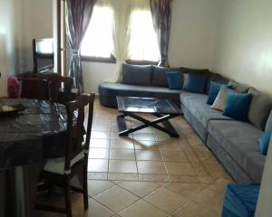 un soggiorno con divano e tavolo di EDyar nakhil Appartement a Marrakech