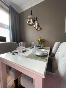 a dining room with a white table and chairs at Altbaucharme Deluxe mit Balkon in zentraler Lage in Kiel