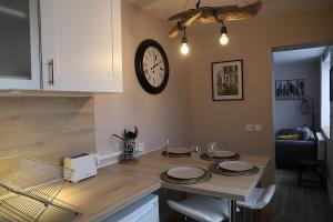 une cuisine avec une table et une horloge au mur dans l'établissement L'appart d'Antoine, à Saint-Quentin 8 autres photos