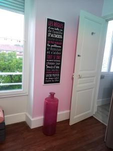 a pink room with a vase in front of a wall at Studio 253, classé 2 étoiles, proche des thermes in Vittel