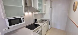 Kuchyňa alebo kuchynka v ubytovaní Homes of Spain, Apartamentos Paraiso Vera Playa, Ed Tahiti, Atico F de 2 dormitorios con piscina privada en solárium y barbacoa, pie de playa