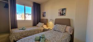Posteľ alebo postele v izbe v ubytovaní Homes of Spain, Apartamentos Paraiso Vera Playa, Ed Tahiti, Atico F de 2 dormitorios con piscina privada en solárium y barbacoa, pie de playa