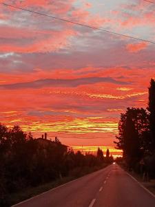 an empty road with a sunset in the background at Agriturismo Il Cipresso in Vada