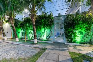 un edificio con palmeras delante en Excelente Casa de Temporada em Porto de Galinhas casa 3 en Porto de Galinhas