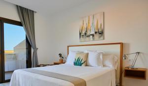a bedroom with a bed with white sheets and a window at ABLANCAS - La Restinga in La Restinga