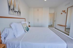 a large white bed with white sheets and pillows at ABLANCAS - La Restinga in La Restinga