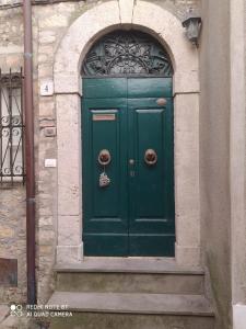 eine grüne Tür an der Seite eines Gebäudes in der Unterkunft Corte delle Oche in Semproniano