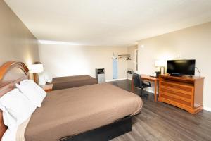 una camera d'albergo con letto e scrivania con TV di Oxford Inn a Oxford