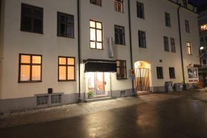 biały budynek na ulicy w nocy w obiekcie Vattengrändens Vandrarhem & Hotel w Norrköping