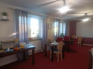 een eetkamer met tafels en stoelen en een raam bij Villa Zdrojowa in Otmuchów