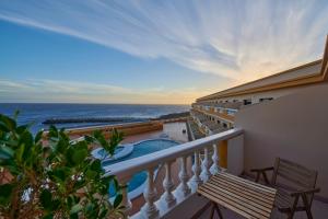 a balcony with a view of a swimming pool and the ocean at ABLANCAS - La Restinga in La Restinga